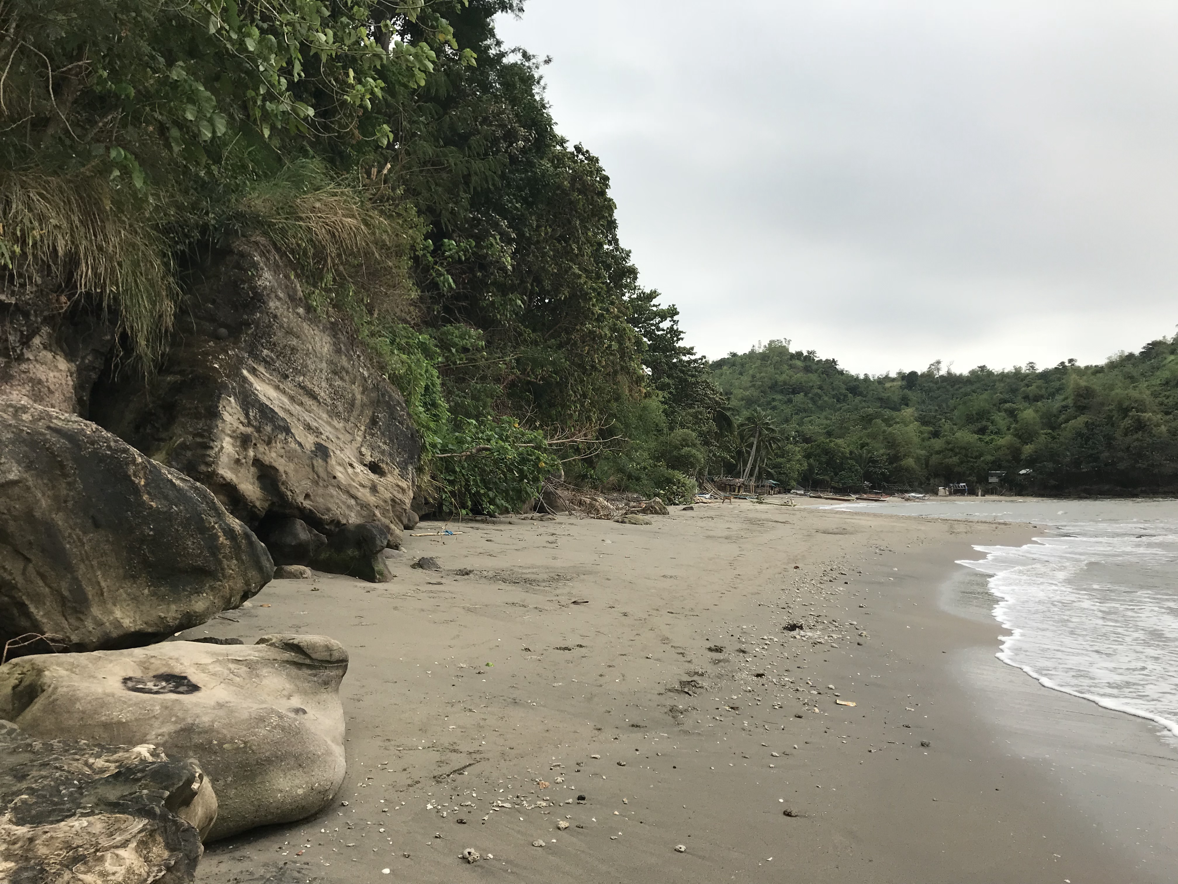 Beach curving past rocks and a green headland at Ternate Beach Resort, Cavite