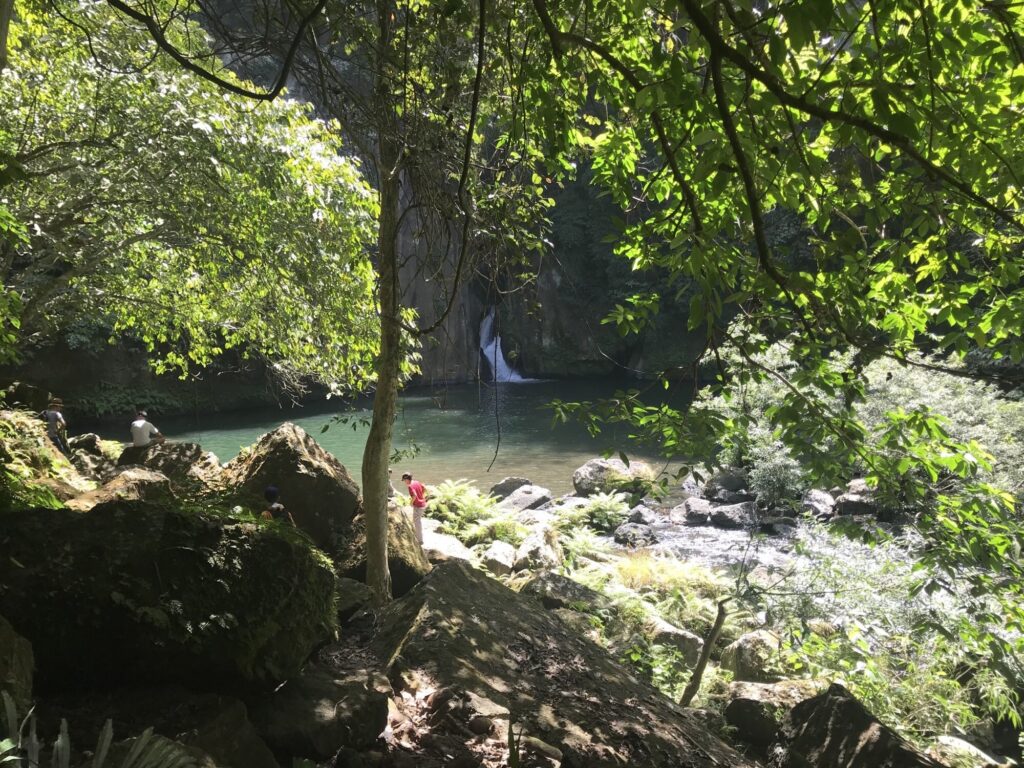 Shaded pool and rocks seen through the trees at Malibiclibic Falls, Cavite