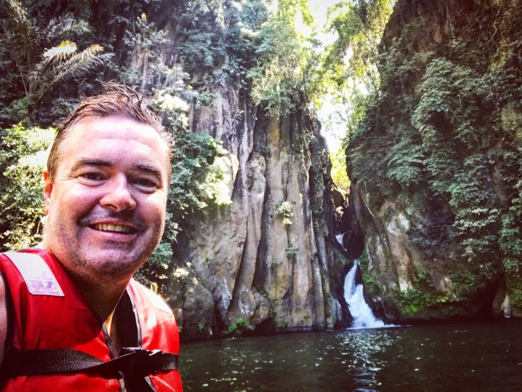 Dezza in a life jacket in front of the gorge at Malibiclibic Falls, Cavite