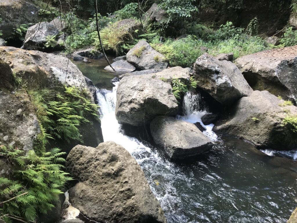 Water cascading over boulders below Malibiclibic Falls, Cavite