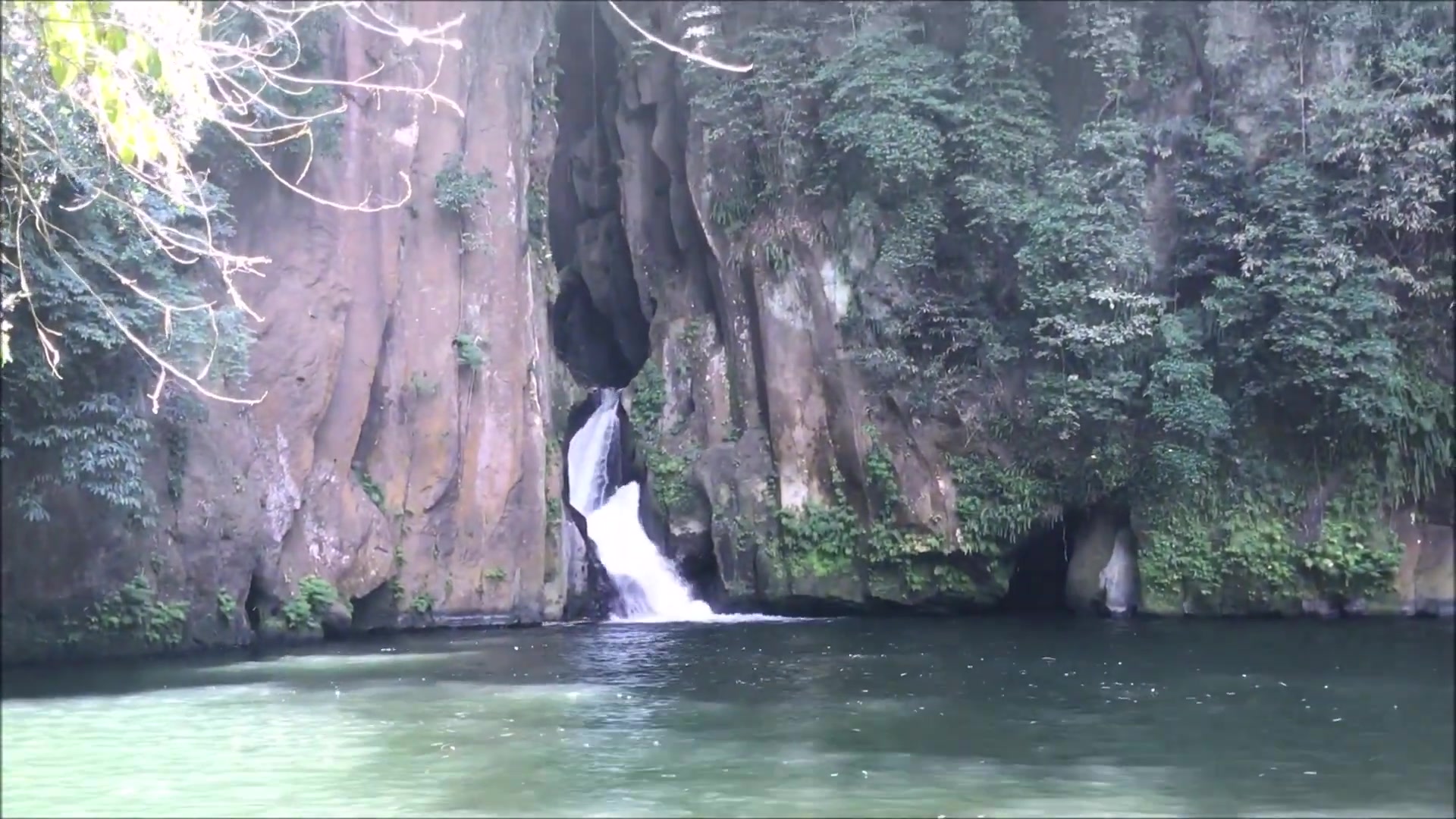 Waterfall dropping into the green pool of the gorge at Malibiclibic Falls, Cavite