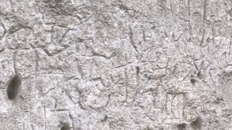 Faint human figures engraved in the rock wall at the Angono-Binangonan Petroglyphs