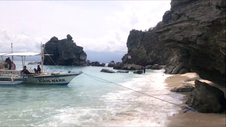 Tour boat moored in a rocky cove on Apo Island