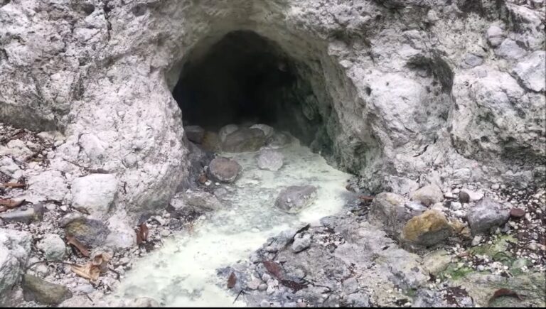 Sulphur-stained thermal outlet in rock at Baslay Hot Springs
