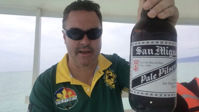 Dezza holding a San Miguel beer on the boat while waiting for the tide at Manjuyod Sandbar