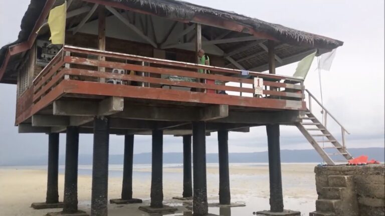 Close view of a stilt cottage on dry sand at low tide, Manjuyod Sandbar
