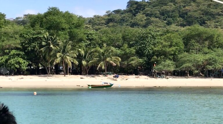 Panutsutan Beach in Nasugbu with a small banca on the sand and forested hills behind