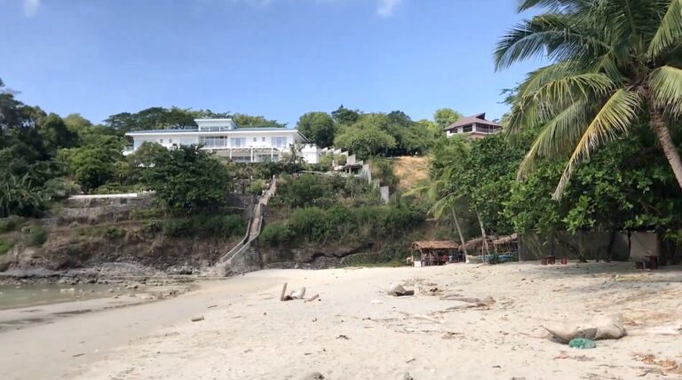 White house on the hillside above the beach at Panutsutan Beach, Nasugbu