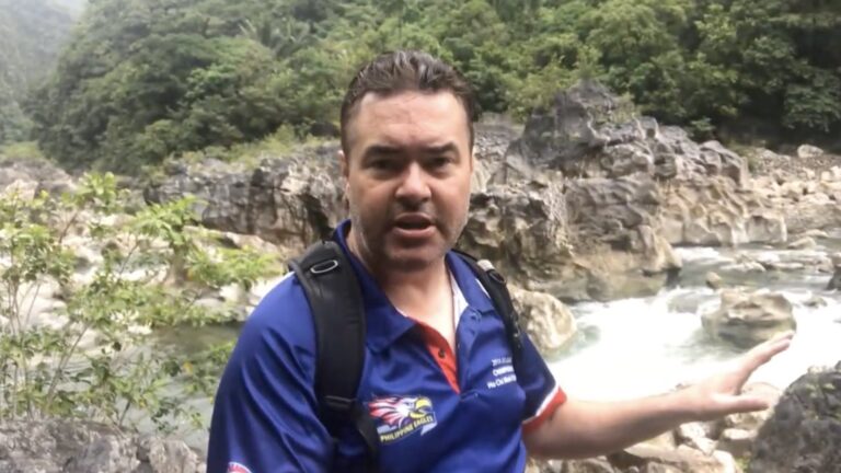 Dezza beside the rapids on Tinipak River during the hike to the cave