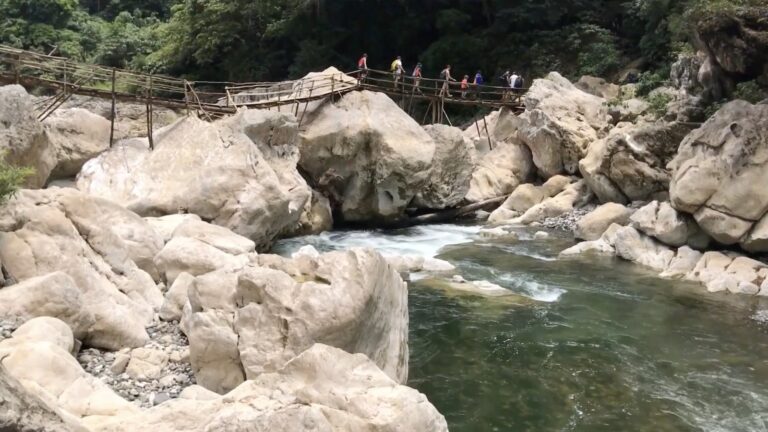 Hikers crossing a bamboo footbridge over Tinipak River in Tanay, Rizal